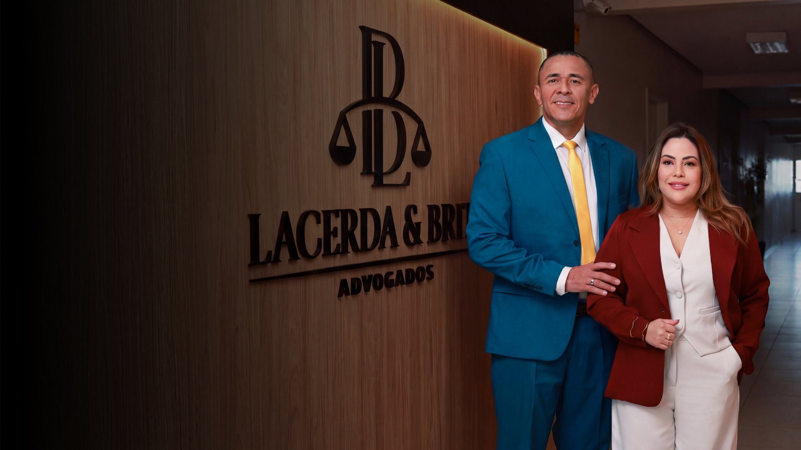 Dr. Ortembeck Lacerda e Dra. Naiane Brito, sócios fundadores, ao lado do letreiro do escritório Lacerda & Brito Advogados